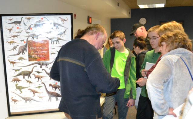 Michael Grenier discusses dinosaurs with two Walworth students and their coach. 