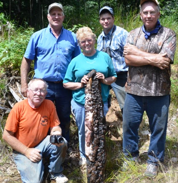 No, that is not a sturgeon or salmon Linda is holding.  Rather these five proud rockhounds are showing off the slab extracted by all the sawing in the previous picture.  Can you spot the two large apatites near Linda’s knee?  Each is about 4” long and 2” in diameter and they present a nice symmetric balance to the meter tall piece featuring dark pyroxene crystals.  