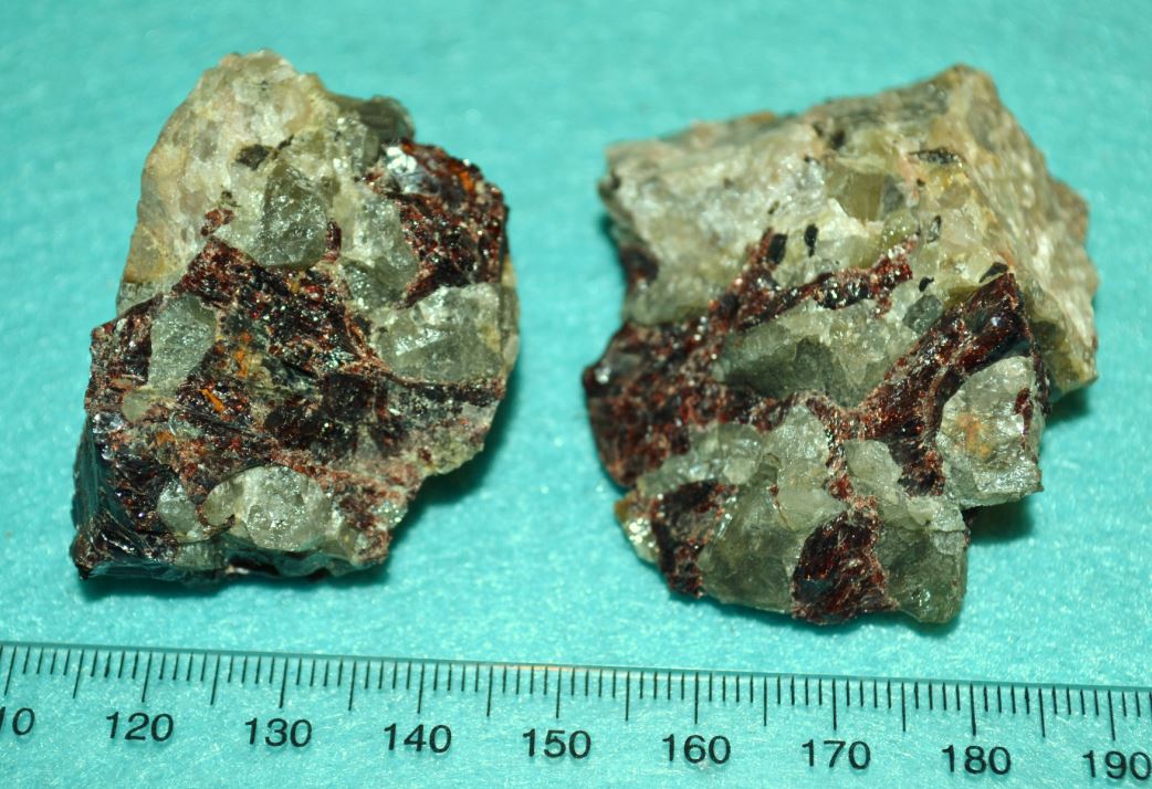 Chrysoberyl (green) and almandine garnet (red) intergrown within pegmatite boulders found on the Benson Mines dumps.